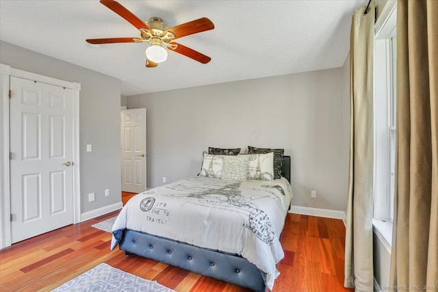 bedroom featuring ceiling fan, wood-type flooring, and a textured ceiling