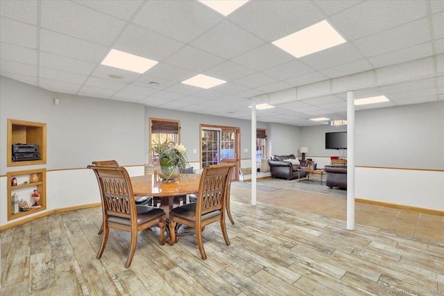 dining space featuring light hardwood / wood-style floors and a drop ceiling