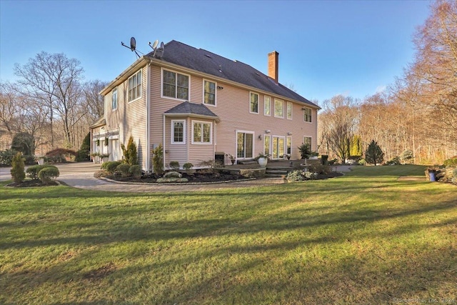 back of house featuring a garage and a yard