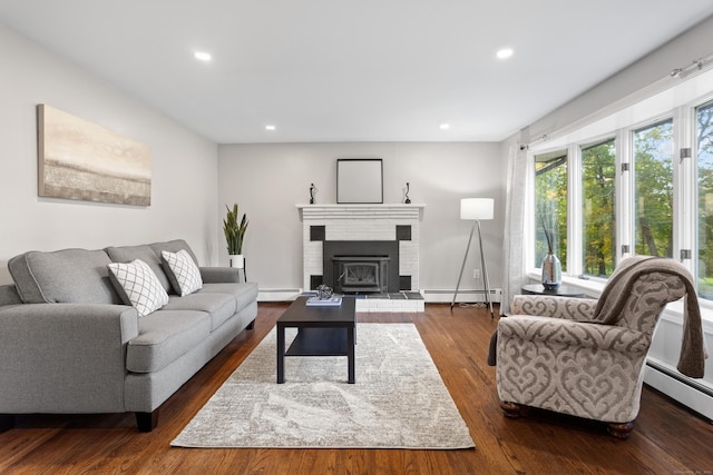 living room with a fireplace, a baseboard radiator, and hardwood / wood-style flooring