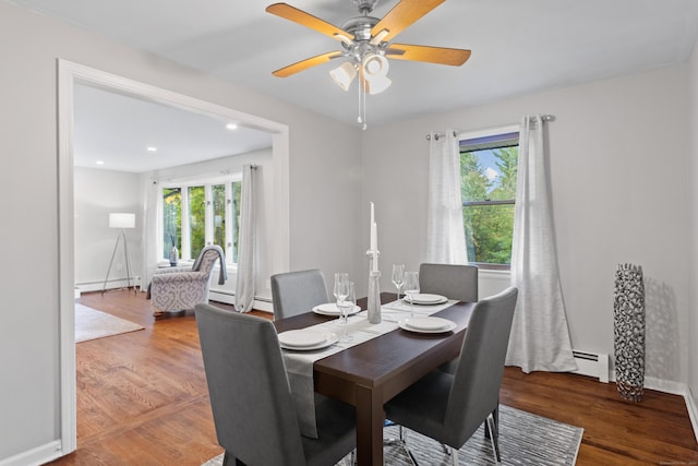 dining area with hardwood / wood-style flooring, baseboard heating, a healthy amount of sunlight, and ceiling fan