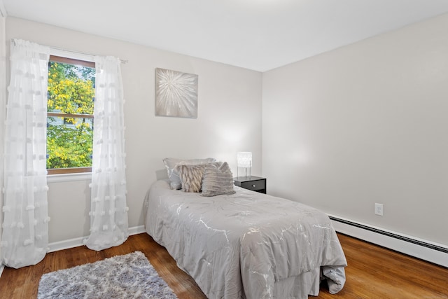 bedroom featuring hardwood / wood-style floors and a baseboard radiator