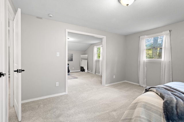 bedroom with vaulted ceiling, baseboard heating, light carpet, and multiple windows