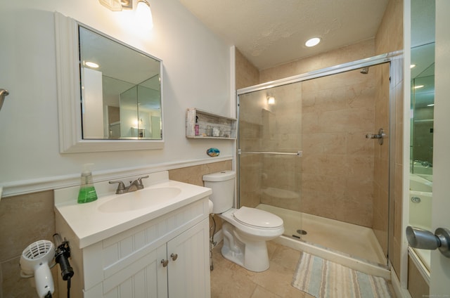 bathroom with tile patterned floors, toilet, a shower with door, and a textured ceiling