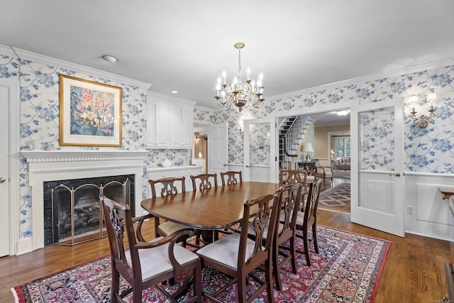 dining area with dark hardwood / wood-style floors, an inviting chandelier, and crown molding