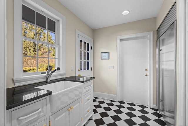 kitchen featuring white cabinetry and sink