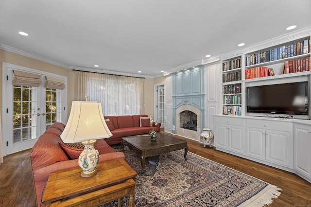 living room featuring a large fireplace, ornamental molding, dark wood-type flooring, and french doors