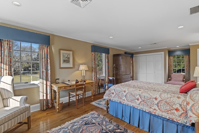 bedroom featuring a closet, ornamental molding, and hardwood / wood-style flooring