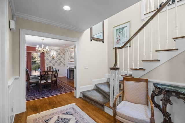 entrance foyer featuring ornamental molding, a chandelier, and hardwood / wood-style flooring