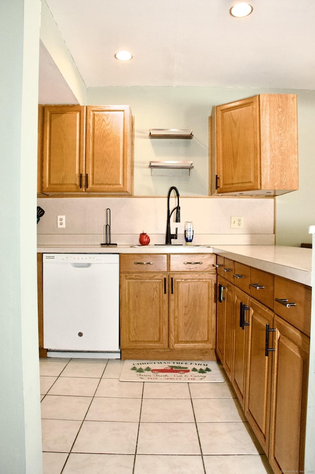 kitchen featuring white dishwasher, light tile patterned floors, and sink