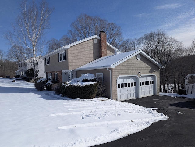 view of snow covered exterior with a garage