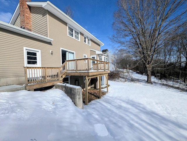 snow covered house with a deck