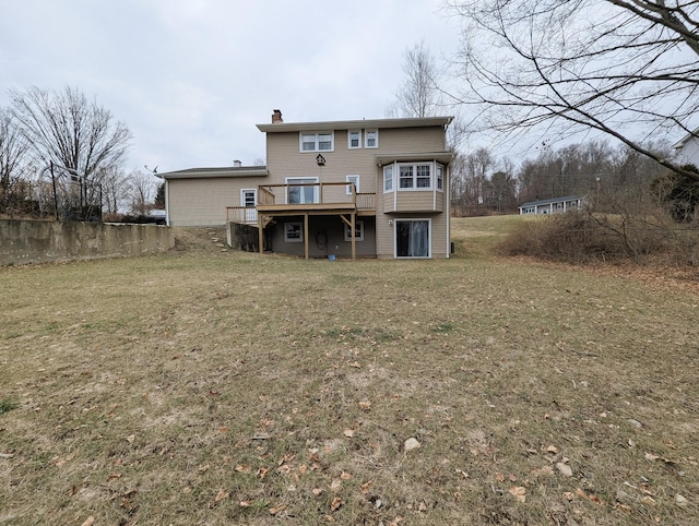 back of property with a wooden deck and a lawn