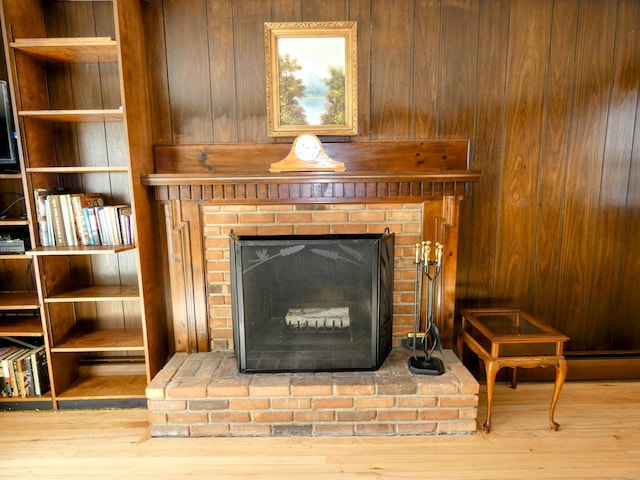 details featuring hardwood / wood-style flooring, wood walls, a fireplace, and built in shelves