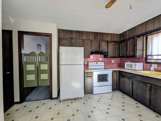 kitchen featuring white appliances, sink, dark brown cabinets, and backsplash