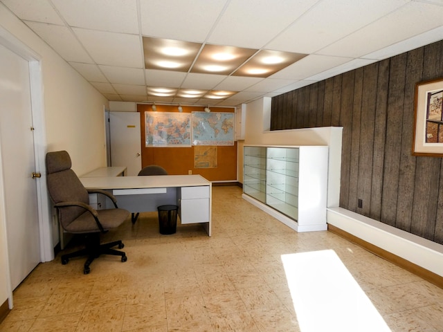 office area with wooden walls and a paneled ceiling