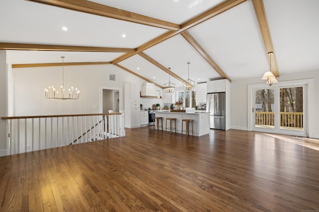 unfurnished living room featuring vaulted ceiling with beams, dark hardwood / wood-style floors, and an inviting chandelier