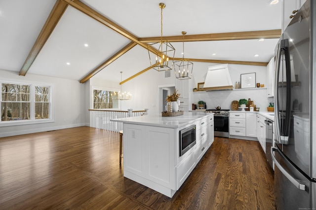 kitchen with stainless steel appliances, lofted ceiling with beams, decorative light fixtures, white cabinets, and a chandelier