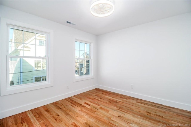 empty room with a wealth of natural light and light wood-type flooring