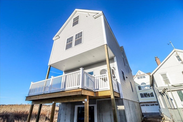 rear view of house with a wooden deck and a garage