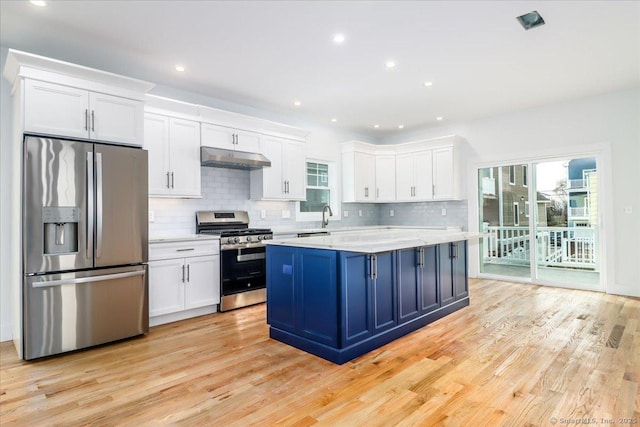 kitchen featuring stainless steel appliances, light hardwood / wood-style floors, a kitchen island, and white cabinets