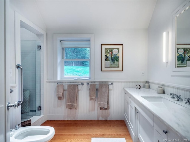 bathroom featuring vanity, wood-type flooring, a shower with door, and vaulted ceiling