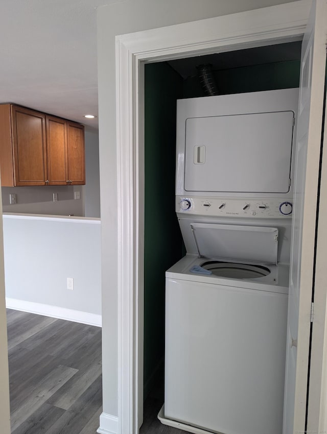 laundry room with stacked washer and dryer and wood-type flooring