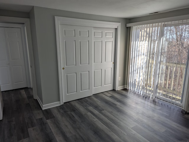 unfurnished bedroom featuring a closet and dark hardwood / wood-style floors