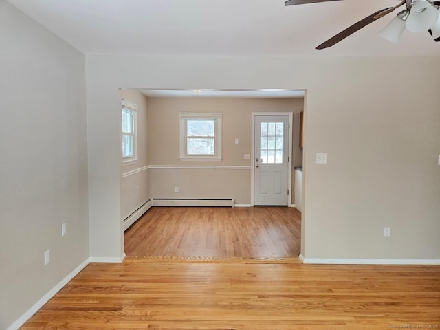 entryway with ceiling fan, a baseboard heating unit, and light hardwood / wood-style flooring