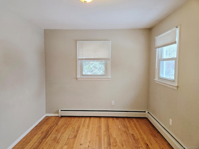 spare room featuring light wood-type flooring and baseboard heating