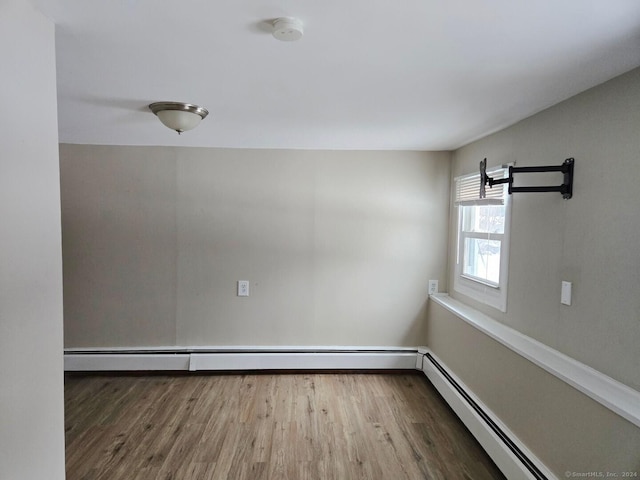 spare room featuring hardwood / wood-style flooring and baseboard heating