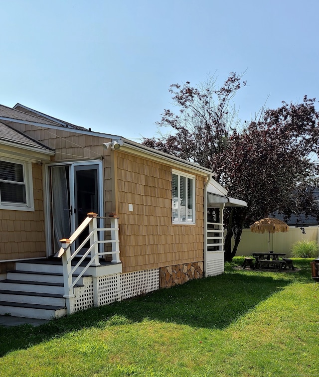 rear view of property featuring a lawn