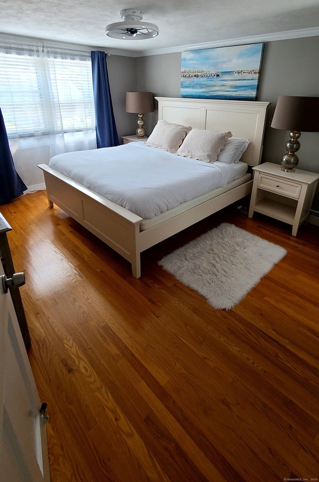 bedroom with hardwood / wood-style flooring and ornamental molding