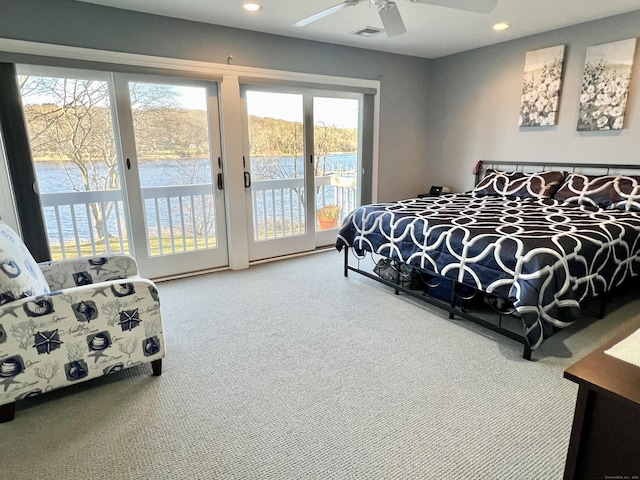 bedroom with access to exterior, ceiling fan, a water view, and multiple windows