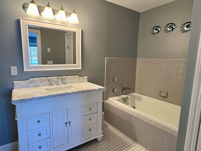 bathroom featuring tile patterned flooring, vanity, and tiled tub