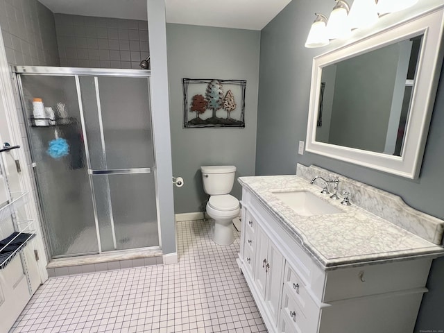 bathroom featuring tile patterned flooring, vanity, toilet, and an enclosed shower