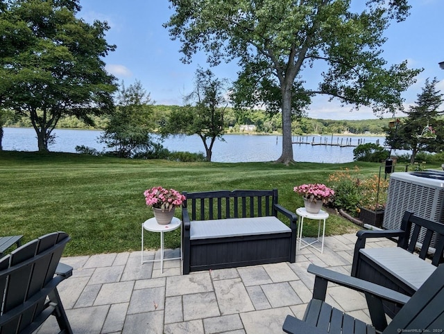 view of patio with central AC unit and a water view