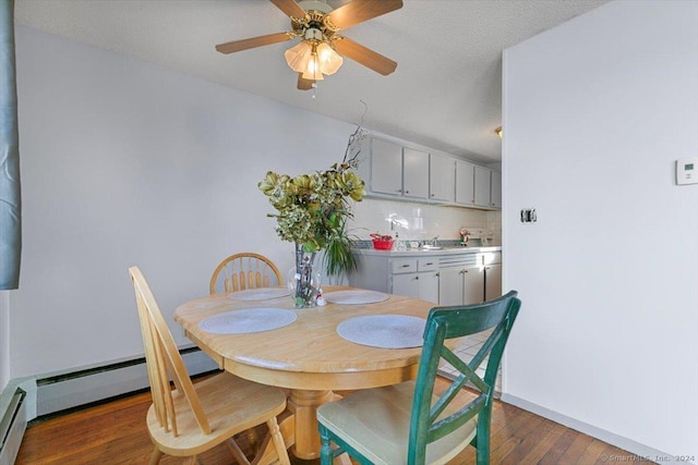 dining area featuring dark hardwood / wood-style flooring, a baseboard radiator, and a textured ceiling