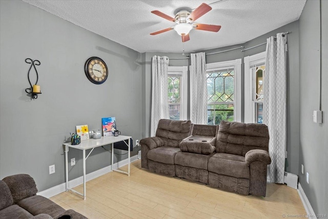 living room with hardwood / wood-style floors, ceiling fan, a textured ceiling, and a baseboard radiator