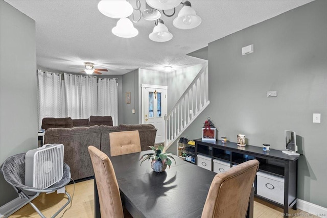 dining space featuring ceiling fan, light hardwood / wood-style flooring, and a textured ceiling