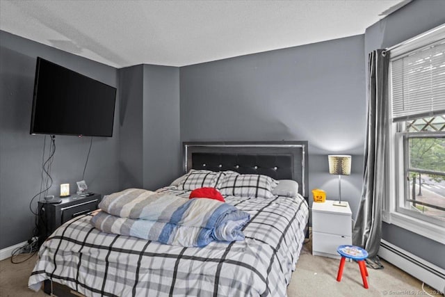 bedroom featuring carpet flooring, a textured ceiling, and a baseboard heating unit