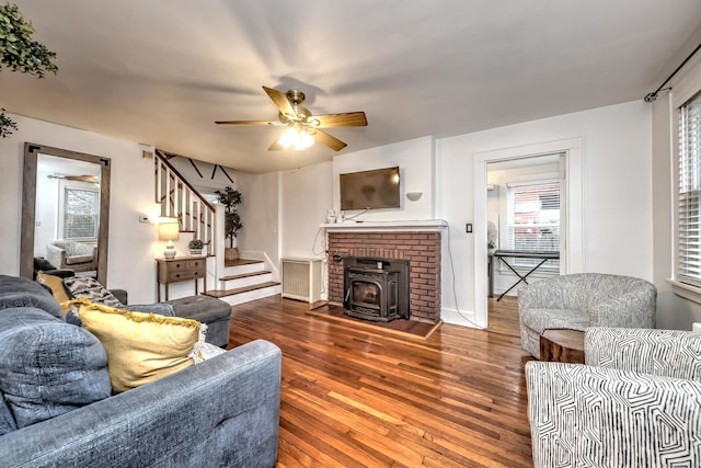 living room with hardwood / wood-style floors, a wood stove, plenty of natural light, and ceiling fan