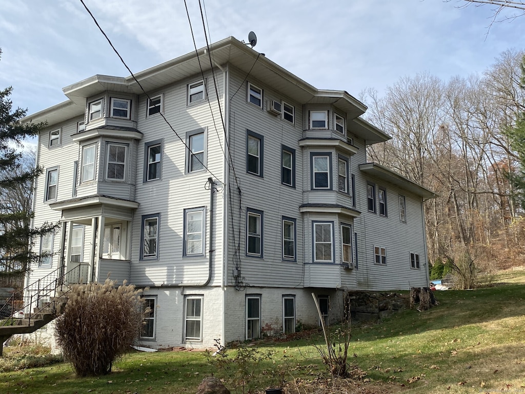 view of side of home with a yard