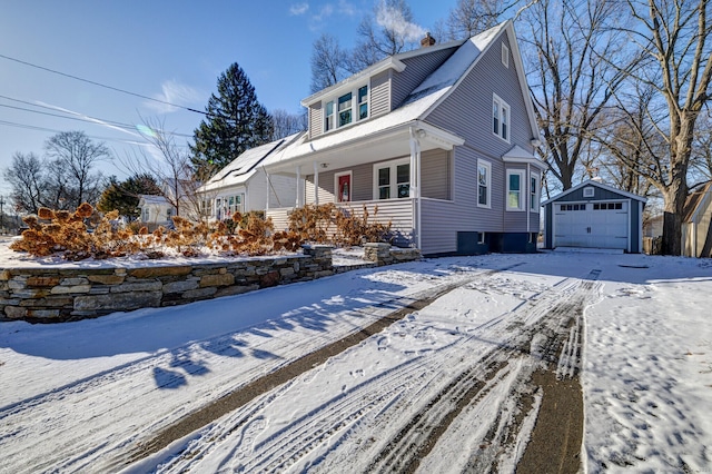 view of property with covered porch, a garage, and an outdoor structure