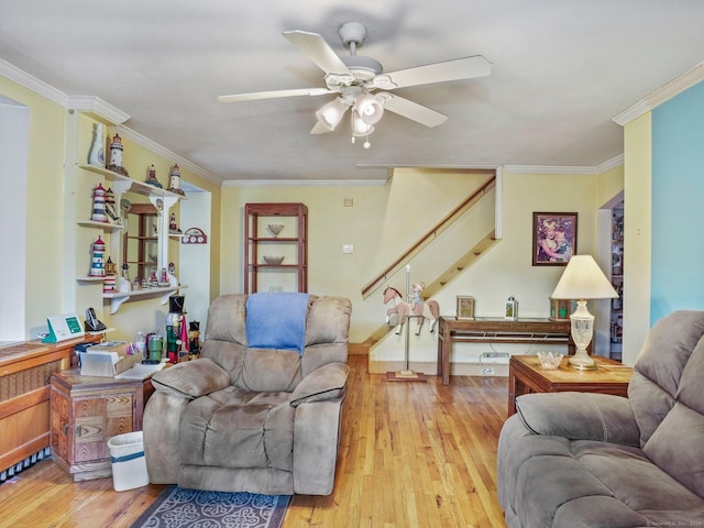 living room featuring ceiling fan, light wood-type flooring, and ornamental molding