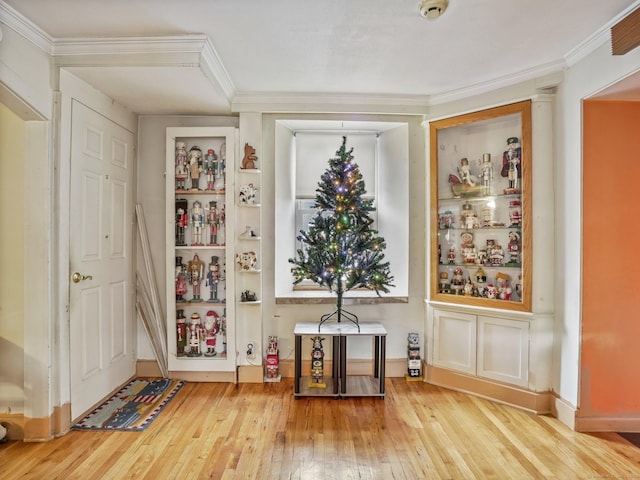 doorway to outside with hardwood / wood-style floors and ornamental molding