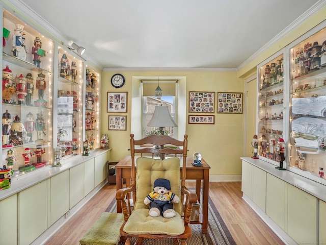 dining room featuring light wood-type flooring and crown molding