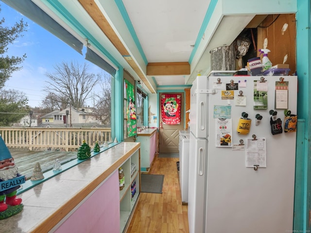 kitchen featuring washer / dryer, white fridge, tile counters, and light hardwood / wood-style floors