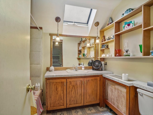 bathroom featuring toilet, vanity, and lofted ceiling with skylight