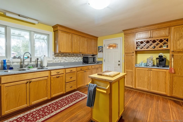 kitchen featuring sink, backsplash, a center island, and dark hardwood / wood-style flooring